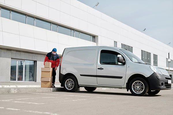 A courier putting a parcel in a van