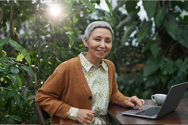 A woman smiling while using her laptop